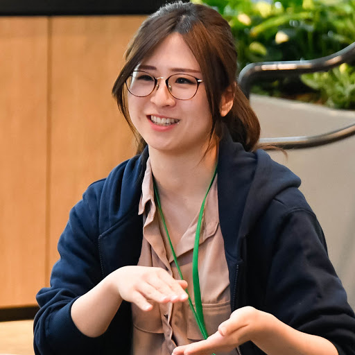 A women with specs smiling.